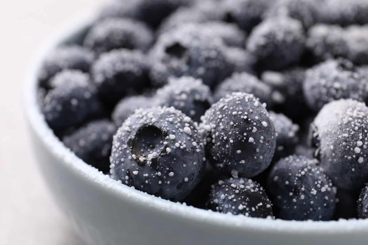 Fresh blueberries in a bowl with sugar crystals on top.