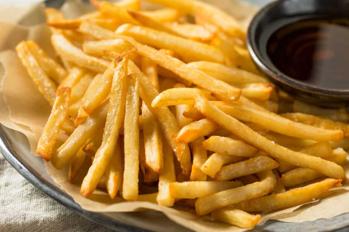 French fries served on a plate with dipping sauce.